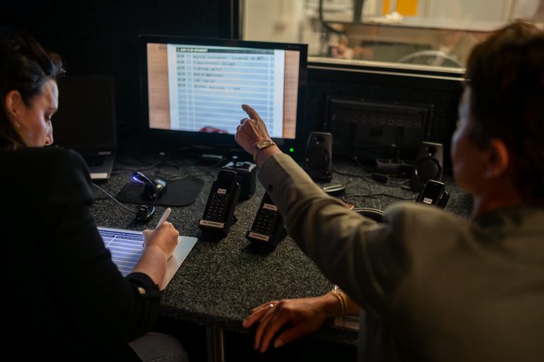Medewerkers in de regieruimte volgen een crisissimulatie